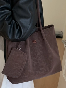 Minimalist chocolate brown tote bag with small pouch shown on model in life style shot