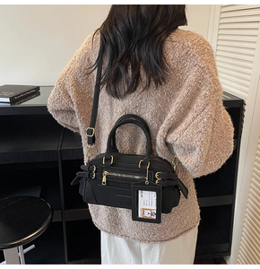 Detail view of black vintage Boston bag featuring retro hardware and hanging card holder tag