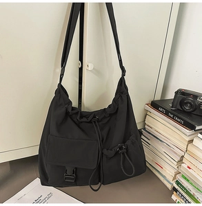 Detail view of large capacity drawstring bucket bag with buckle pocket and nylon texture