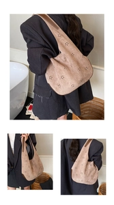 Macro detail of laser-cut flower pattern and matte texture on a khaki bucket bag