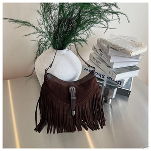 Détail du sac bandoulière en daim marron foncé avec franges bohèmes et boucle vintage