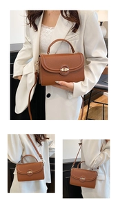 Close-up of caramel brown pebble leather handbag with gold metal twist lock and top handle