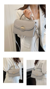 Close-up of light gray crossbody bag with pebble grain leather and golden twist lock detail