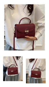 Close-up of burgundy lychee grain leather handbag with golden ring lock and top handle