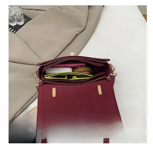 Deep red leather crossbody bag with spacious interior for daily essentials and gold lock