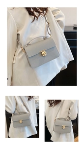Detail showing grey lychee pattern leather handbag with gold round lock and long shoulder strap