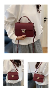 Detail view of burgundy lychee leather handbag with golden twist lock and adjustable strap