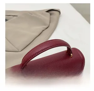 Close-up of wine red lychee grain leather handbag with gold metal hardware and sturdy handle
