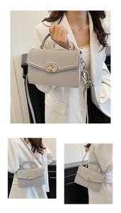 Detail of grey pebbled leather handbag with gold twist lock and adjustable shoulder strap