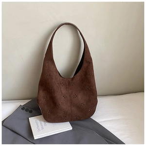 Detailed close-up of dark brown suede hobo bag featuring laser-cut floral patterns on fabric