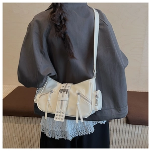 Detail shot of a cream white punk style shoulder bag with rivets and metal zippers