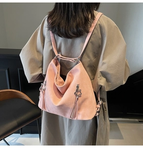 Rear view of a pink suede backpack featuring star charms and long tassels for women