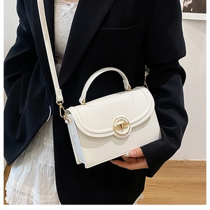 Close-up of cream white lychee grain leather handbag with elegant gold ring hardware