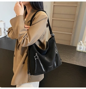 Detail of black hobo bag with star-shaped zipper pulls and white logo lettering