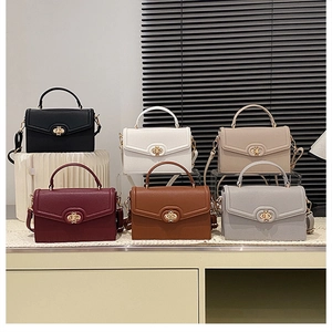 Detail view of colorful faux leather crossbody bags with golden bow metal clasps