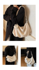 Detail of beige pleated shoulder bag with metal chain and plush bear charm pendant