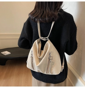 Detailed view of beige hobo backpack with star charm and double vertical zippers