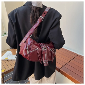 Detail of burgundy biker shoulder bag with silver hardware and adjustable wide strap