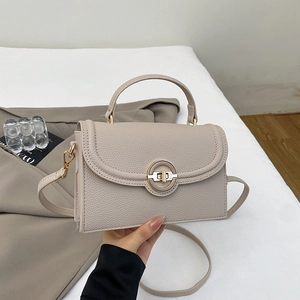 Detail view of lychee pattern leather shoulder bag with golden metal circular ring lock