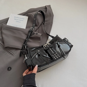 Close-up of black punk shoulder bag with silver metallic zippers and stud details