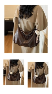 Detail view of coffee brown PU leather bag with silver chain and white teddy bear charm