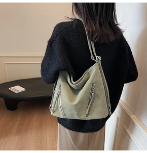 Detail view of sage green matte tote bag featuring stylish star zipper pulls and large capacity