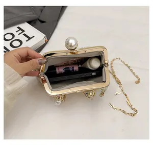 Detail view showing interior capacity of a white pearl lace evening bag with gold chain