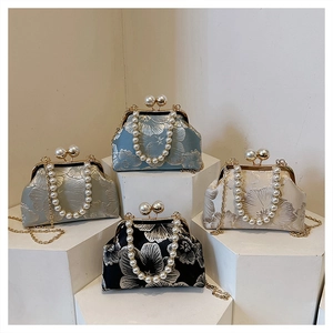 Detailed display of vintage floral brocade clutch bags with pearl handles in four colors