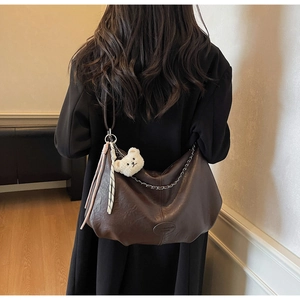 Deep brown oil wax leather shoulder bag detail with chain and cute bear charm pendant