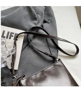 Detailed view of the dark brown leather strap and smooth texture on a vintage bucket bag