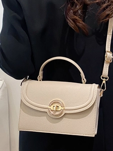 Chic beige crossbody bag with lychee texture and golden ring buckle shown on a model