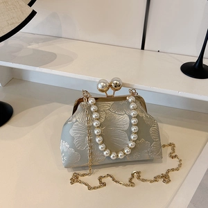 Detailed view of floral embroidery and pearl clasp on this elegant vintage evening bag