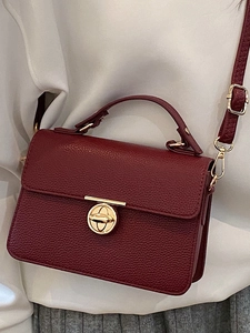 Burgundy lychee texture crossbody bag with gold ring lock shown on stylish outfit