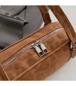 Close-up of vintage brown suede Boston bag featuring a smooth double silver metal zipper
