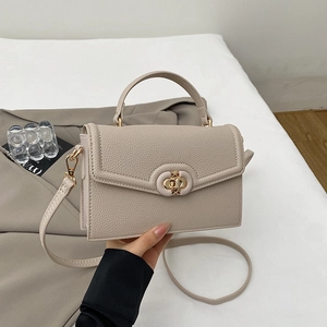 Detail of beige pebble leather flap handbag with gold-tone twist lock and top handle