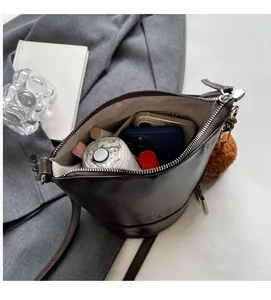 Detail view of large dark brown leather bucket bag showing spacious interior with zipper