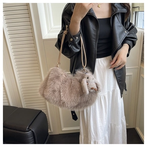 Détail du sac fourre-tout beige en fausse fourrure avec breloque lapin et anses en cuir