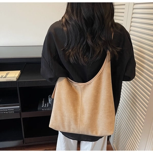 Détail du grand sac cabas en daim kaki porté par un mannequin pour un style urbain chic