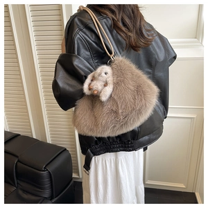 Détail d'un sac cabas en peluche marron avec un charm lapin mignon et une fine bandoulière