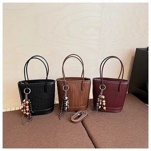 Detailed woven leather bucket bags in black and brown with boho beads and strap
