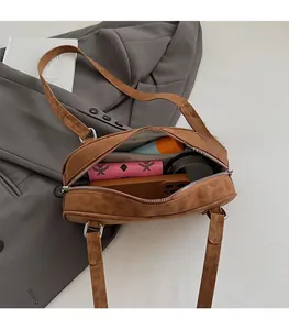 Detail view of large interior capacity and zipper closure of the caramel suede shoulder bag