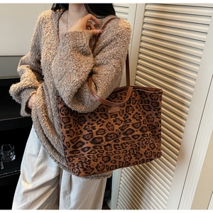 Detailed view of large leopard print tote bag with leather handles and canvas texture