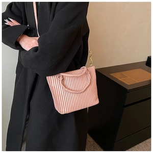 Close-up of pink pleated bucket bag with circular handles and metal hook details