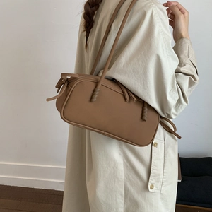 Detailed view of brown matte shoulder bag with unique spiral braided knot on strap