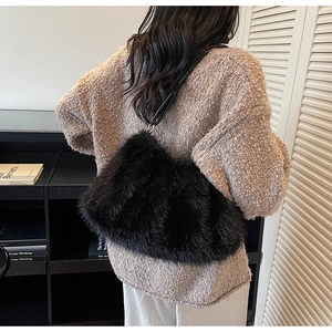 Détail du sac à main en fausse fourrure noire avec une texture soyeuse et bandoulière en cuir