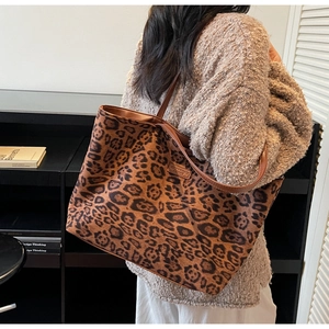 Detailed shot of large leopard print tote bag featuring brown faux leather straps and brand label