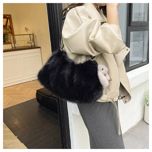 Détail du sac à main en peluche noire avec un porte-clé lapin mignon sur la bandoulière