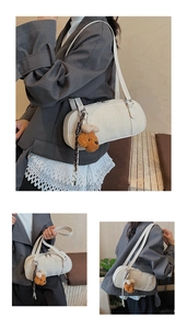 Detail of cream bowling bag showing branded embossing, texture, and bear charm