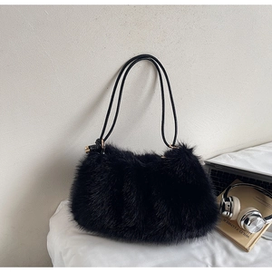 Détail du sac bandoulière en fausse fourrure noire avec lanières en cuir et anneaux dorés