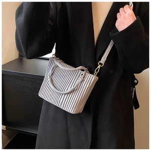 Detail of light grey pleated bucket bag with gold hardware and stylish shoulder strap
